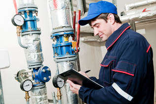 worker looking at commercial plumbing
